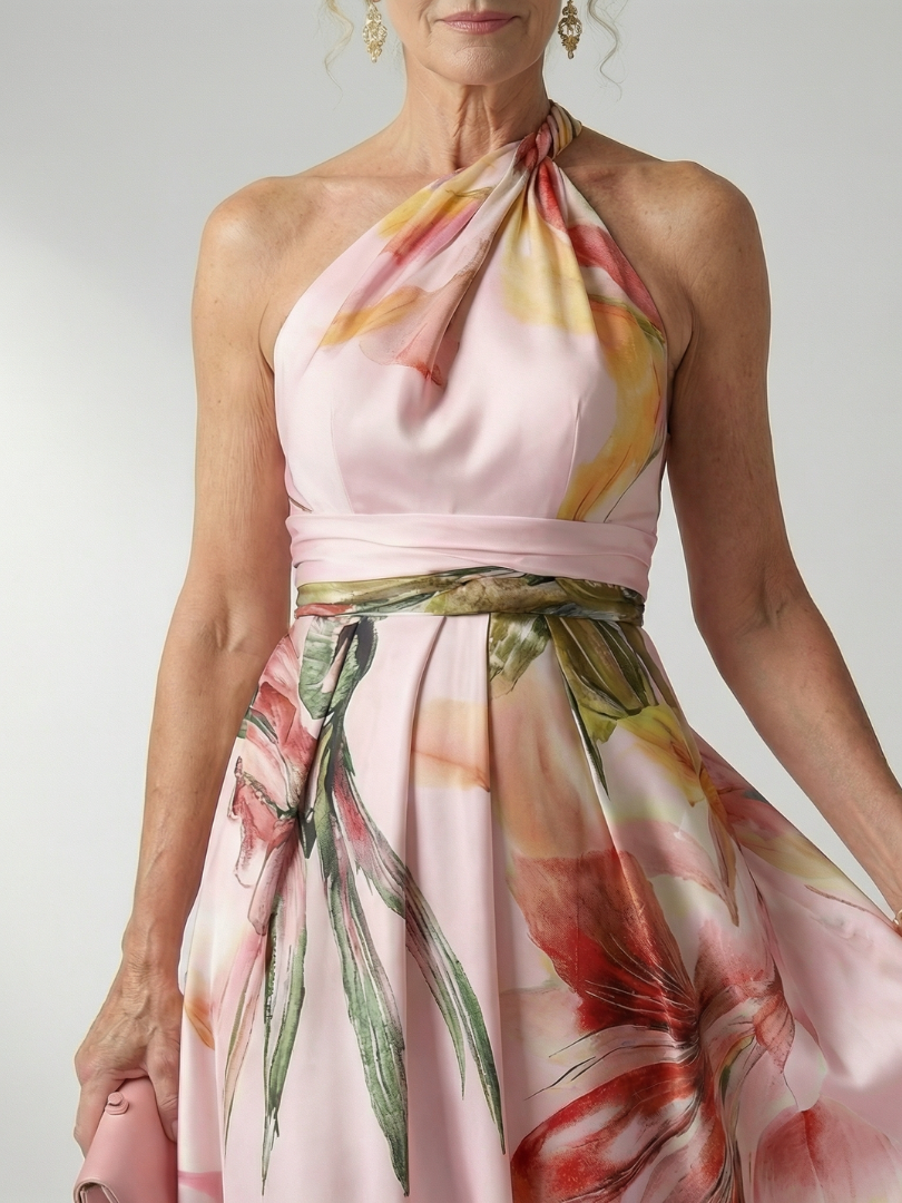 Close-up of pink halter maxi dress with gathered neck tie and floral belted waist