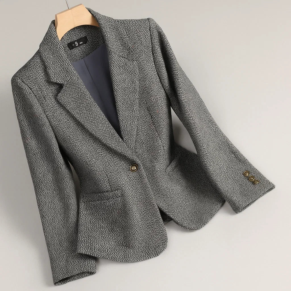 Gray tweed blazer with notch lapels, single-breasted front, gold-tone buttons at cuffs