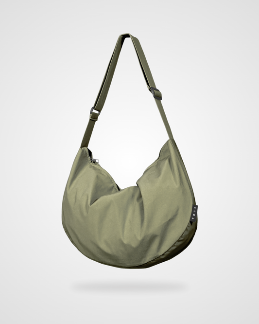 Olive green structured crossbody bag with wide shoulder strap and curved hobo shape