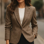 Beige tweed blazer worn over a white top; single-button closure and long sleeves