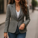 Gray tweed blazer worn over a white top; single-breasted front and long sleeves