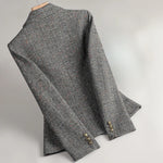 Gray tweed blazer sleeve and cuff details with gold-tone button embellishment