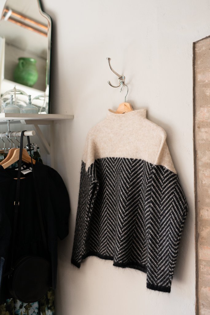 Hanging beige and black chevron turtleneck pullover sweater with ribbed collar.
