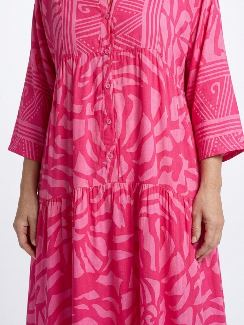 Pink button-front midi dress detail: V-neck placket with buttons and tiered bodice.